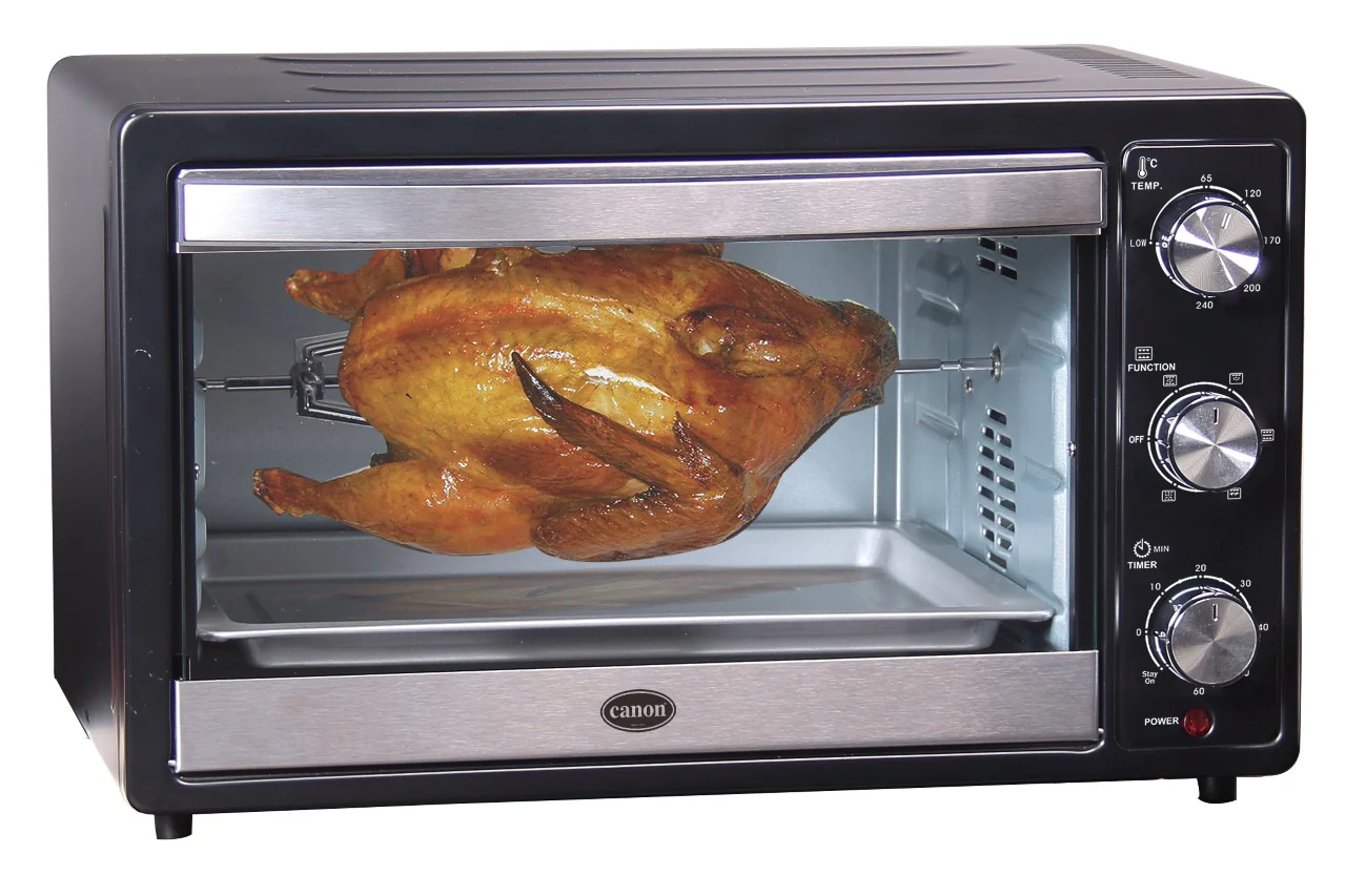 A whole roast chicken on a rotisserie spit inside the CHA-EOT-35-01 35L Canon Electric Oven Toaster, featuring three right-side control knobs and premium imported quality.