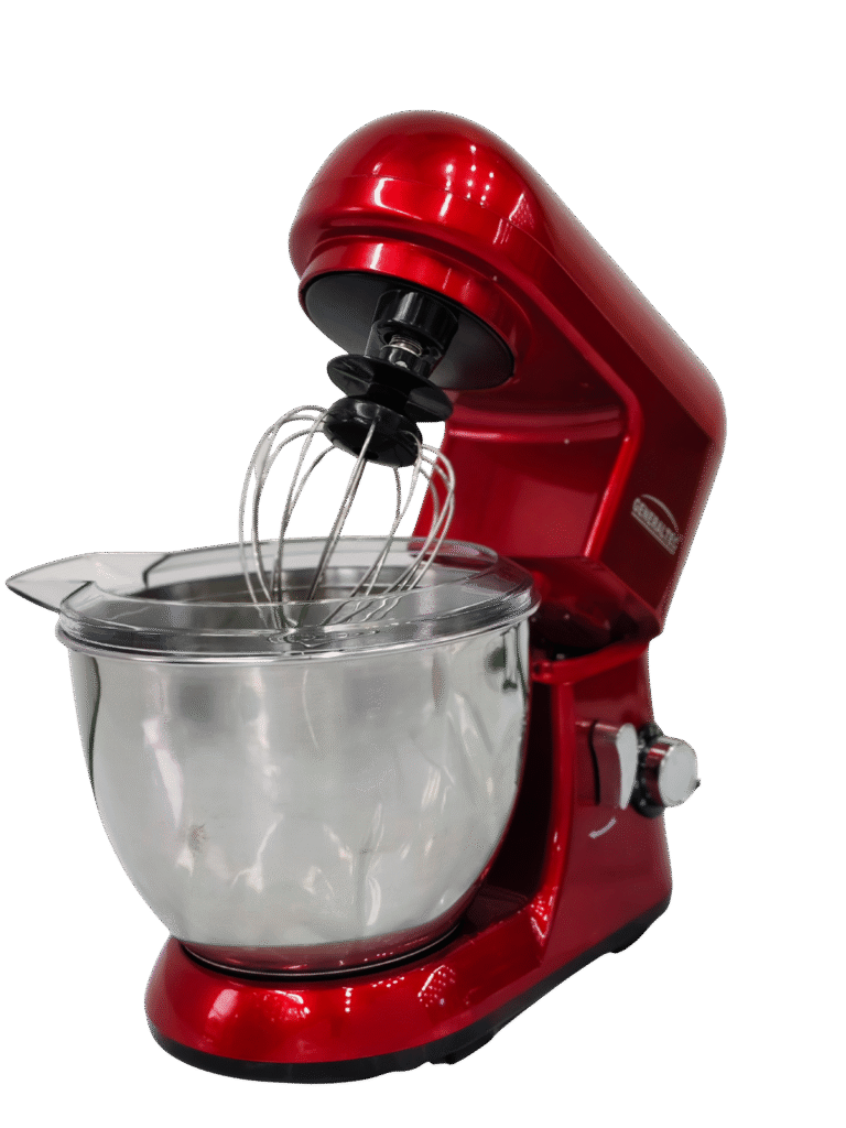 The GM-983-02.png is a red stand mixer featuring a stainless steel mixing bowl, wire whisk attachment, a raised head, and a partially fitted bowl cover.