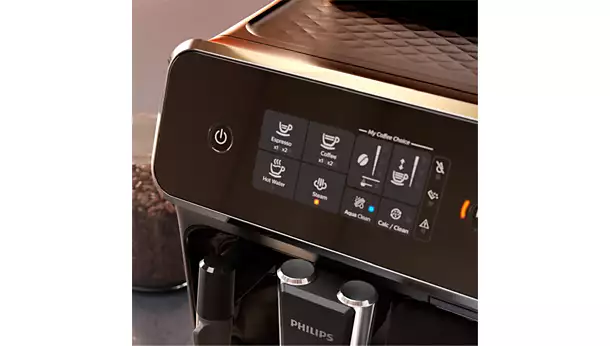 Close-up of the vrs_2200-06.webp coffee machine touchscreen showing options like espresso, coffee, and cappuccino, with a side power button and a coffee beans container in the background.